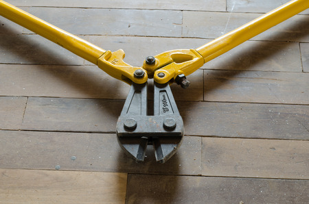 yellow bolt cutter on wooden floor,industrial toolsの写真素材