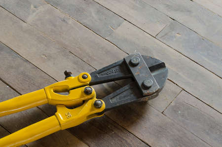 yellow bolt cutter on wooden floor,industrial toolsの写真素材