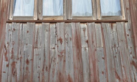wooden wall with four windowsの写真素材