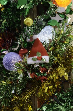 santa hat on the christmas tree with colorful beauty cotton light lamp in happy new year celebrationの写真素材