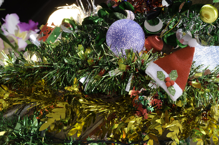 santa hat on the christmas tree with colorful beauty cotton light lamp in happy new year celebrationの写真素材