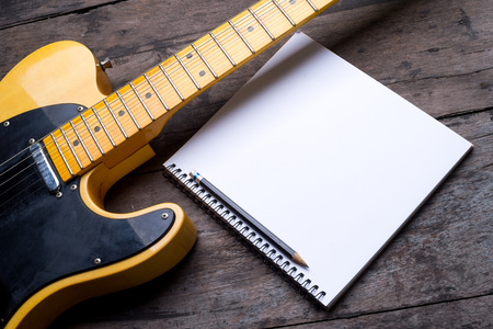 electric guitar telecaster with notepad on wood deskの写真素材