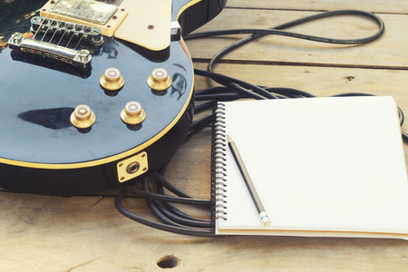 electricguitar with notepad on wood tableの写真素材