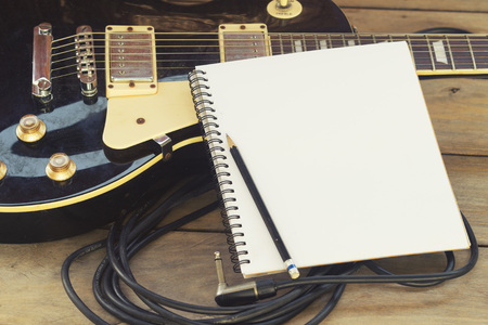 electricguitar with notepad on wood tableの写真素材
