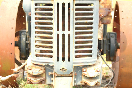 Rusty old tractor sits alone in the field on a farmの写真素材