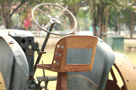 Rusty old tractor sits alone in the field on a farmの写真素材