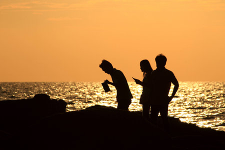 Silhouette of people in the evening at the beach.の写真素材