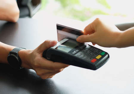 Man using credit card swipe machine for sell products in the shop to customers. Concept of spending via credit card.の写真素材