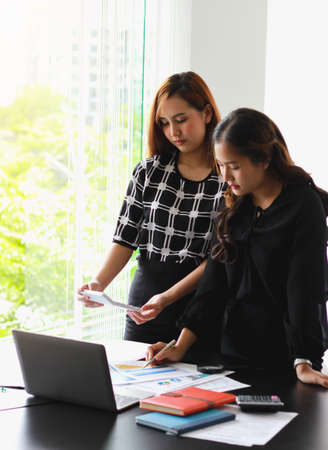 Business People Meeting to analyse and discuss and brainstorming the financial report chart data in...