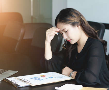 Concept Burnout Syndrome. Business Woman feels uncomfortable working. Which is caused by stress, accumulated from unsuccessful work And less resting body. Consult a specialist psychiatrist.の写真素材
