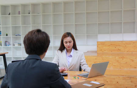 Businesswoman or accountant working pointing graph discussion and analysis data charts and graphs and using a calculator.の写真素材