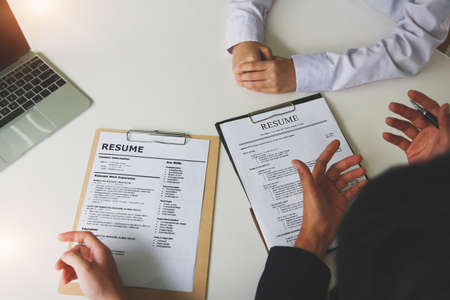 Office job interviews with HR personnel holding resume and background checks on applicants with prepared skills.の写真素材