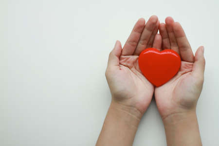 Woman holding heart on white background, top view with space for text. Donation conceptの写真素材