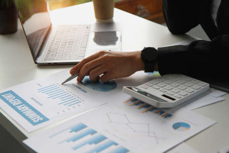 Financial advisor calculating numbers datasheets graphs charts reports marketing research...
