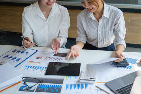 Marketing, Financial, Accounting, Planning, Team of female businessmen and economists use calculators and computers and graph documents to profit the company.の写真素材