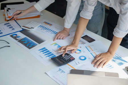 Marketing, Financial, Accounting, Planning, Team of female businessmen and economists use calculators and computers and graph documents to profit the company.の写真素材