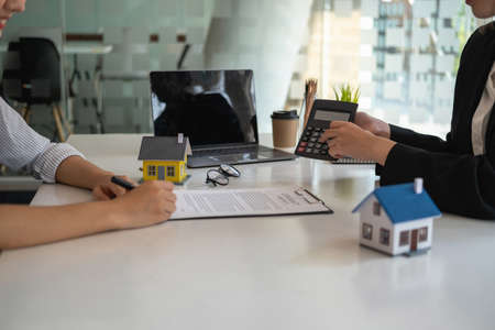 Buying houses and land, guarantees, contract and agreement, An employee of a real estate company hands over the house and keys after the contract for the sale of land and buildings is complete.の写真素材