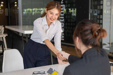 Buying houses and land, guarantees, contract and agreement, An employee of a real estate company hands over the house and keys after the contract for the sale of land and buildings is complete.の写真素材