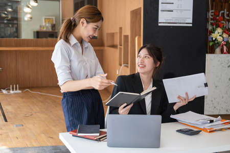 Marketing, Financial, Accounting, Planning, Team of business women analyze company results and profits with graph statistics. Use a laptop computer and a calculator to calculate the company's balance.の写真素材