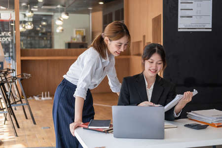 Marketing, Financial, Accounting, Planning, Team of business women analyze company results and profits with graph statistics. Use a laptop computer and a calculator to calculate the company's balance.の写真素材