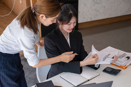Marketing, Financial, Accounting, Planning, Team of business women analyze company results and profits with graph statistics. Use a laptop computer and a calculator to calculate the company's balance.の写真素材