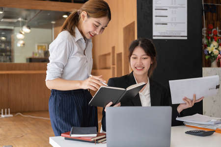 Marketing, Financial, Accounting, Planning, Team of business women analyze company results and profits with graph statistics. Use a laptop computer and a calculator to calculate the company's balance.の写真素材