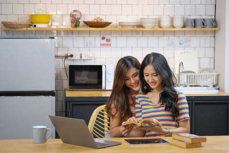 lgbtq, lgbt concept, homosexuality, two beautiful women showing their love to each other in a very warm home happilyの写真素材