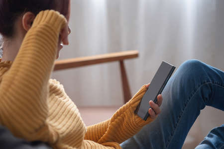 relax, de-stress, holiday, happy, Asian woman relaxing at home listening to music from smartphone and laptop happily.の写真素材