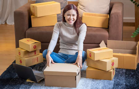 relax, relieve stress, holiday, happy, Asian woman relax at home Use your laptop computer to watch movies and listen to music on vacation.の写真素材