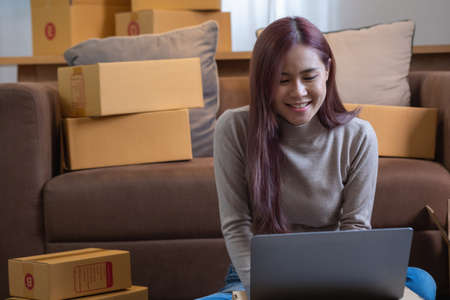 relax, relieve stress, holiday, happy, Asian woman relax at home Use your laptop computer to watch movies and listen to music on vacation.の写真素材