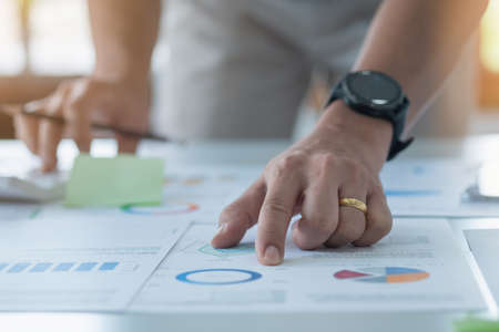 businessman use calculators and graph analysis computer laptop tablets to plan marketing strategies and make profitable investments for the company.の写真素材