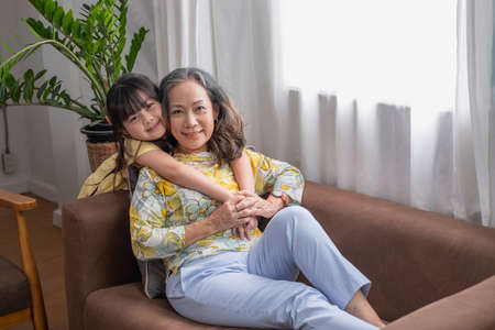 Portrait of a grandmother and granddaughter doing home activities and showing love for one another to create warmth and love within the family.の写真素材