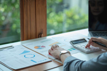 Marketing, Finance, Accounting, Planning, Businesswomen use calculators, computers, and graphs to...
