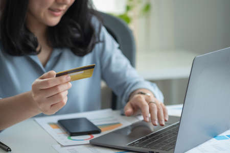 Businesswoman presenting profit data with graphs to her supervisor via laptop computer.