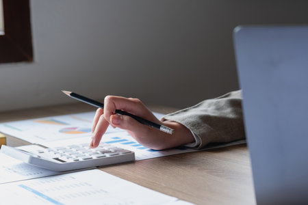Businesswoman presenting profit data with graphs to her supervisor via laptop computer.の写真素材