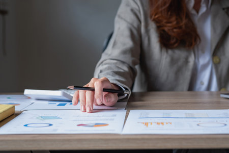 Businesswoman presenting profit data with graphs to her supervisor via laptop computer.の写真素材