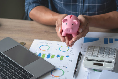 man holding a coin to drop a piggy bank For saving money for the future of the family, saving ideas.の写真素材