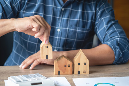 Accountant, businessman, real estate agent, businessman handing model house to customers along with house interest calculation documents for customers to sign.の写真素材