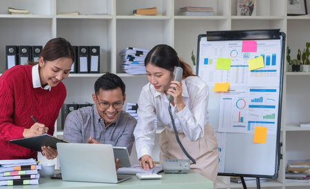 Marketing, Finance, Accounting, Planning, A team of businessmen plan with their laptops and graph charts for their profits and use a calculator to calculate their company is annual balance.の写真素材