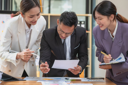 Marketing, Finance, Accounting, Planning, A team of businessmen plan with their laptops and graph charts for their profits and use a calculator to calculate their company is annual balance.の写真素材