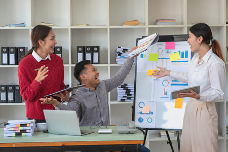 Marketing, Finance, Accounting, Planning, A team of businessmen plan with their laptops and graph charts for their profits and use a calculator to calculate their company is annual balance.の写真素材