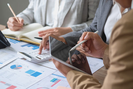 The company is team of marketers analyzes the company is profits using laptop computer graphs and calculators.の写真素材