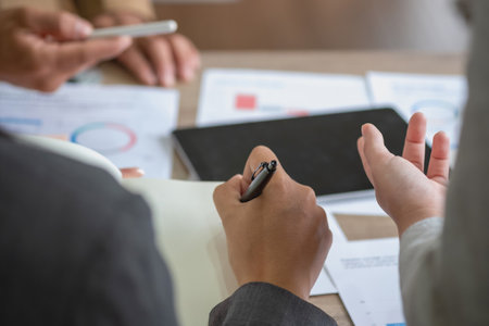 Team of business use calculators and graph analysis computer laptop tablets to plan marketing strategies and make profitable investments for the company.の写真素材