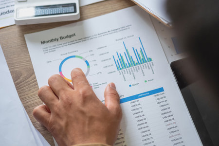 Marketing, Finance, Accounting, Planning, A team of businessmen plan with their laptops and graph charts for their profits and use a calculator to calculate their company is annual balance.の写真素材