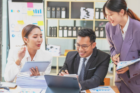 Team of Asian businessmen helping to brainstorm management ideas for the company are expressing joy and happiness that the company has achieved commercial success.の写真素材