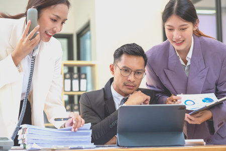 A team of three Asian businessmen is working inside an office where businessmen in black suits are being ordered by their supervisors and bosses a lot causing stress at work. burnout conceptの写真素材