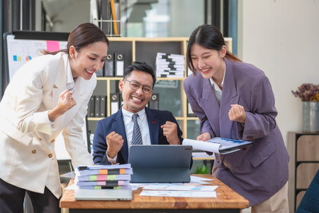 Team of Asian businessmen helping to brainstorm management ideas for the company are expressing joy and happiness that the company has achieved commercial success.の写真素材
