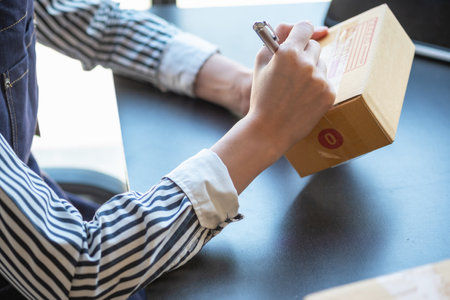 Asian female entrepreneur starting an online sales business using laptops, tablets, and smartphones to place orders and check products inside her own office, SME online concept.の写真素材