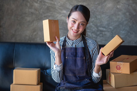 Asian female entrepreneur starting an online sales business using laptops, tablets, and smartphones to place orders and check products inside her own office, SME online concept.の写真素材