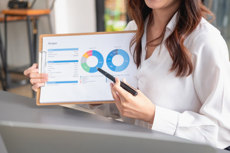 Marketing, Financial, Accounting, Planning, business women analyze company results and profits with graph statistics. Use a laptop computer and a calculator to calculate the company is balance.の写真素材